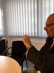 Jürgen Bothner am rechten Bildrand im Profil, Hände gestikulieren.