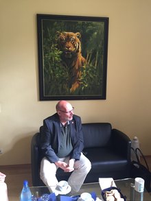 Bothner auf Ledersofa im Zoodirektorbüro unter Ölgemälde eines Tigers.