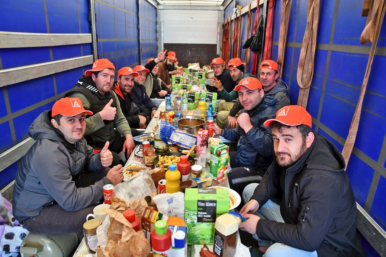 Die streikenden LKW-Fahrer an einer langen Tafel beim Essen