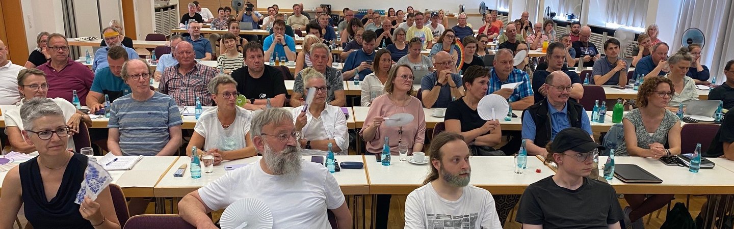 Blick von vorn auf die Konferenzteilnehmer*innen.